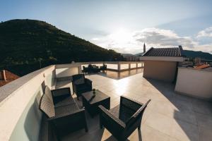 a patio with chairs and tables on a balcony at Elegant Studio Apartments Lasta in Mostar
