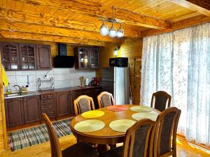 y cocina con mesa, sillas y nevera. en Дом в Жабляке с шикарным видом на Дурмидор en Žabljak