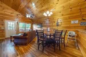 a living room with a table and chairs in a cabin at Blackberry Bijou in Pigeon Forge