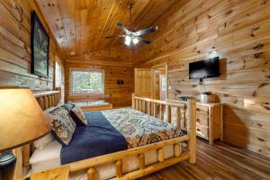 1 dormitorio con 1 cama en una cabaña de madera en Blackberry Bijou, en Pigeon Forge