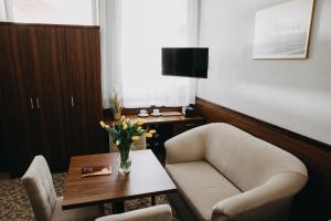 una habitación de hotel con una silla y una mesa con flores en Willa Irena, en Solec-Zdrój