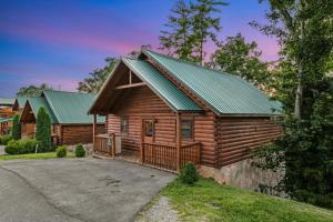 a log cabin with a green roof at Blackberry Bijou in Pigeon Forge