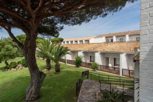 an exterior view of a building with a tree at Parador de Mazagón in Mazagón
