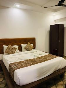 a bedroom with a large bed with brown and white pillows at Goa Divine Candolim in Calangute