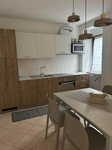 a kitchen with white cabinets and a table and chairs at la tana del viaggiatore in Cavedago