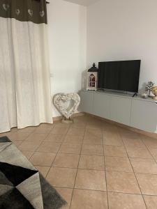 una sala de estar con TV de pantalla plana en un armario en la tana del viaggiatore, en Cavedago