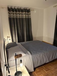 1 dormitorio con 1 cama y 1 mesa con lámpara en la tana del viaggiatore, en Cavedago
