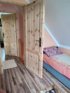1 dormitorio con 1 cama y suelo de madera en Domek Żegary, en Sejny