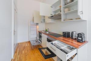 a kitchen with white cabinets and a wooden counter top at Premium apartment - walking distance to city center in Graz