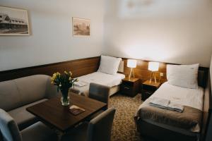 pokój hotelowy z 2 łóżkami i stołem w obiekcie Willa Irena w Solcu-Zdroju