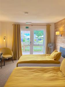 a hotel room with two beds and a window at Shenstone Lodge in Kidderminster