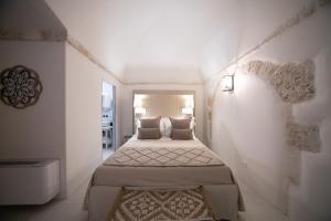 a small white room with two beds in it at San Marco Boutique Rooms in Alberobello