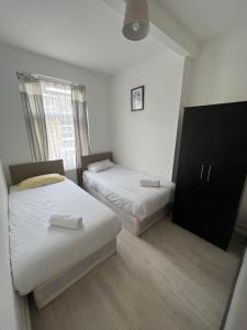 a room with two beds and a dresser in it at Miles 4floor in London