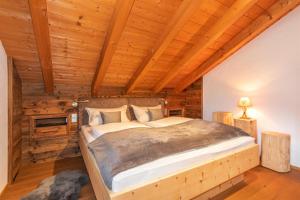 Un dormitorio con una cama grande en una habitación con techos de madera. en Ferienhaus Alpenblick, en Mittenwald