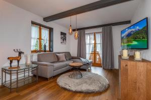 a living room with a couch and a tv at Ferienhaus Alpenblick in Mittenwald