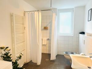 a bathroom with a shower curtain and a toilet at Sonnenschein Appartement in Wuppertal in Wuppertal