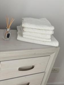 uma pilha de toalhas em cima de uma cómoda em Apartament Grand Hill 1 em Oradea