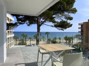 a patio with a table and chairs and the ocean at Rentalmar Suites Salou Families Only in Salou