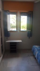 um quarto com duas janelas e uma cama. em Roquetas de mar em Roquetas de Mar