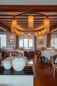 a dining room with white tables and chairs at Parador de Mazagón in Mazagón