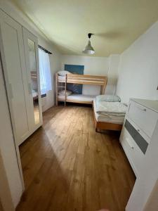 a bedroom with two bunk beds and a wooden floor at Chalupa Kruh in Doksy