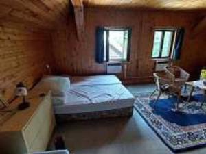 Großes Zimmer mit einem Bett und einem Tisch in der Unterkunft Chalupa Kruh in Doksy