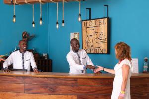 a man and a woman shaking hands at a counter at Neptune in Saly Portudal +53 photos