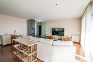 a living room with a white couch and a tv at Ocean View Luxury Apartment in Vila Nova de Gaia
