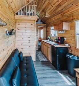 a living room and kitchen in a log cabin at Hollow Hills Tiny Home in Penn Yan