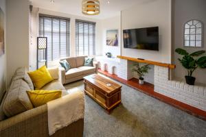 a living room with two couches and a tv at Frodo's Folly by StayStaycations in Port Talbot