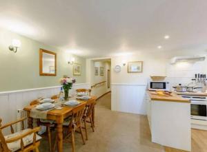 a kitchen and dining room with a table and chairs at Magpie cottage in Pickering