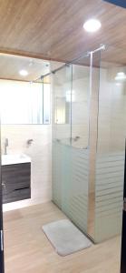 a glass shower in a bathroom with a sink at Apartamento - ApartaSuite ARGUS in Paipa +42 photos