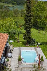 une grande piscine dans une cour avec un arbre dans l'établissement Les Gîtes de L'Yères, à Cuverville-sur-Yères