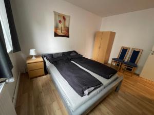 ein Schlafzimmer mit einem Bett und zwei blauen Stühlen in der Unterkunft Schönes einfaches Zimmer im belebten Zentrum in Wilhelmshaven