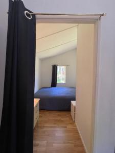 - une chambre avec un lit bleu et une fenêtre dans l'établissement Sjönära stuga, à Norrtälje