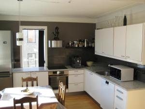 a kitchen with white cabinets and a table in it at Central Reykjavík Apartment in Reykjavík