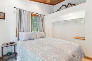 a bedroom with a white bed and a window at Serene Yellville Retreat with Hot Tub on 85 Acres in Cotter