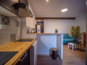 a kitchen with a counter and a blue couch at By les Climats - La Grande Rue in Perrigny-lès-Dijon