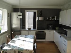 a kitchen with a table and a stainless steel refrigerator at Central Reykjavík Apartment in Reykjavík +8 photos