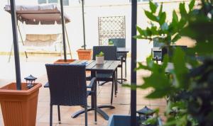 a table and chairs on a patio with plants at Alghero Sunrise in Alghero