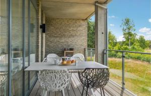 eine Terrasse mit einem Tisch und Stühlen auf dem Balkon in der Unterkunft Gorgeous Apartment In Nimtofte With Wifi in Nimtofte