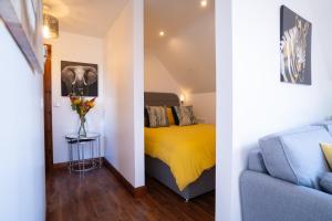 two views of a bedroom with a bed and a couch at Cherry Tree Apartment 