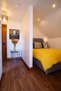 a bedroom with a yellow bed and a table with flowers at Cherry Tree Apartment 
