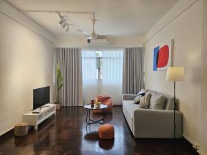 a living room with a couch and a tv at SANT Bangkok at Khaosan Road in Bangkok