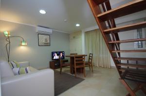 a living room with a couch and a dining room table at Apartamentos Vila Nova in Vila Nova de Milfontes