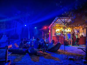 un groupe de personnes assises à terre la nuit dans l'établissement Chillsteps Hostel, à Fethiye