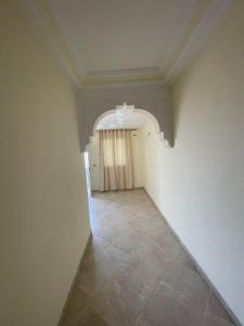 un couloir vide avec une arche et une chambre dans l'établissement Ikamet Lilian, à Tabarka