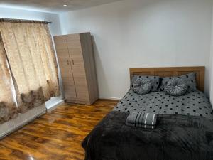 1 dormitorio con 1 cama y suelo de madera en Good priced double bed in Hayes en Northolt