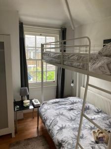ein Schlafzimmer mit Etagenbett und Fenster in der Unterkunft Quaint Edwardian Cottage in London