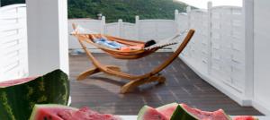 a hammock on a deck with watermelon on a porch at Casa Tommasini in Capaccio-Paestum